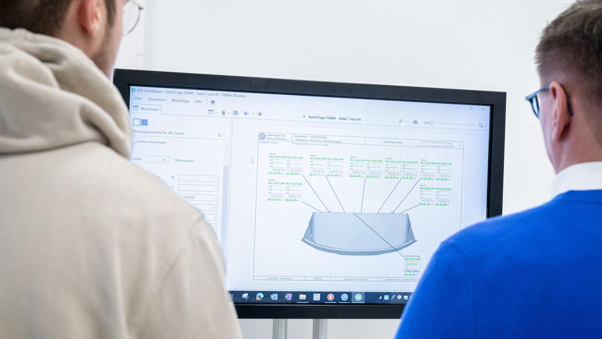 Dr. Achim Schwarz und Dominik Koch prüfen die Messergebnisse in einem ZEISS PiWeb Report.