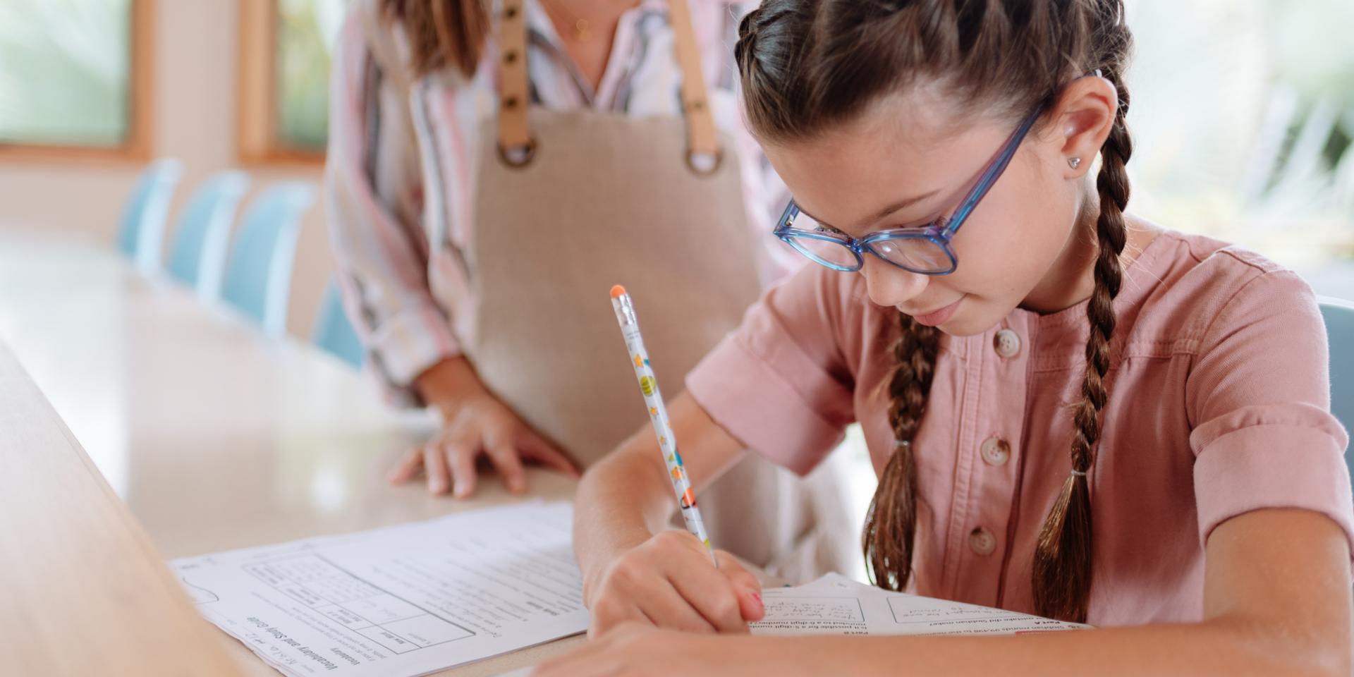 Mädchen mit Brille schreibt mit Stift