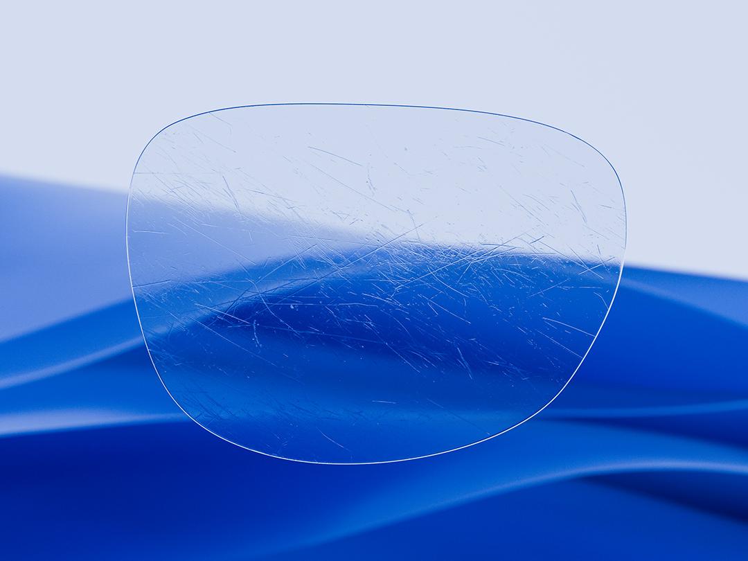 Geteiltes Bild, das auf der einen Hälfte ein ZEISS Glas zeigt, das sich durch seine Klarheit und Sauberkeit auszeichnet, während auf der anderen Hälfte ein zerkratztes herkömmliches Brillenglas zu sehen ist, wodurch der Kontrast bei der Langlebigkeit hervorgehoben wird. 