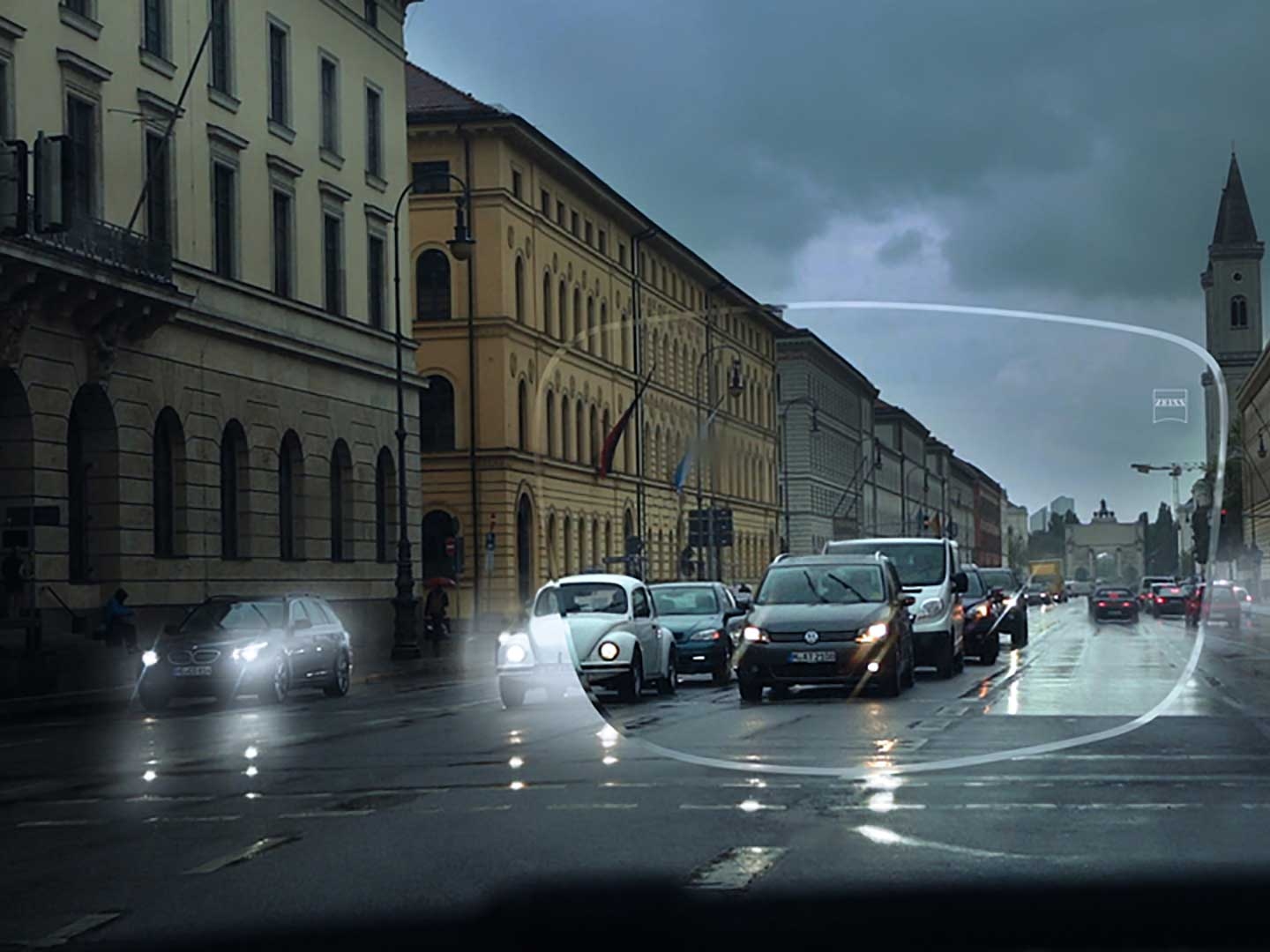 Das Bild veranschaulicht schlechte Sichtverhältnisse unter widrigen Lichtbedingungen auf einer Straße. Dargestellt ist die Sicht durch ein Brillenglas aus dem Auto heraus. 