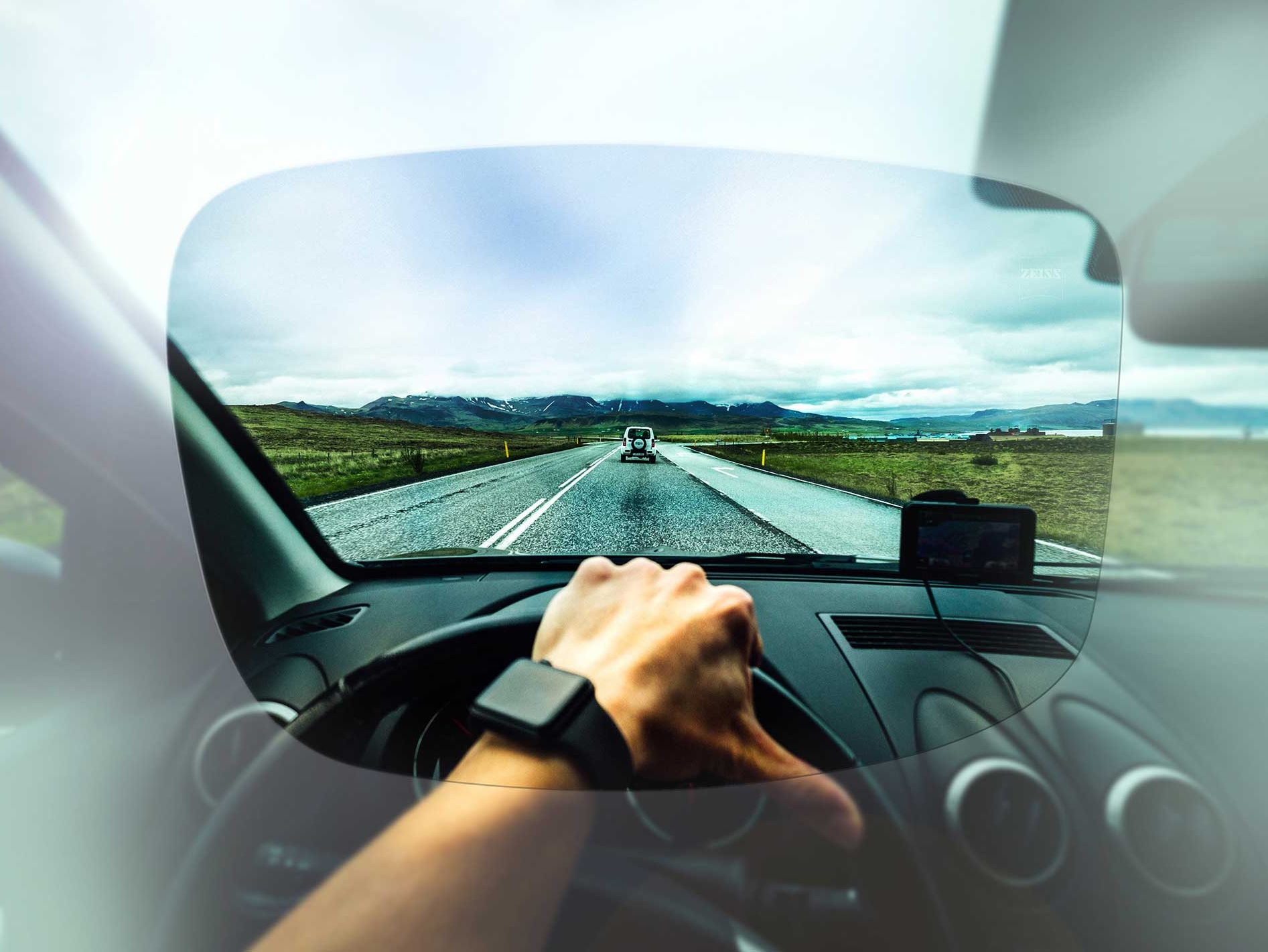 Freie Sicht aus der Fahrerperspektive auf eine Straße und Landschaft durch ein ZEISS Brillenglas aus der Drive-Kollektion